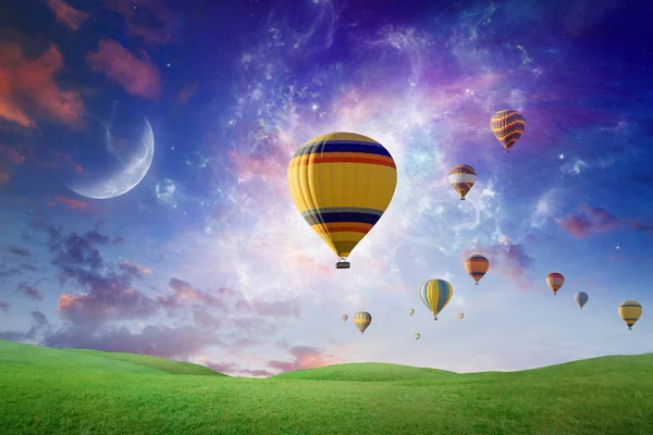 Heißluftballons fliegen vor glühendem Hintergrund in den Abendhimmel lizenzfreie Stockbilder