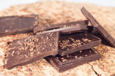 Ahşap masa üzerinde koyu çikolata. Çikolata kırıntı