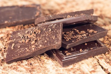 Ahşap masa üzerinde koyu çikolata. Çikolata kırıntı