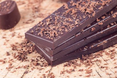 Ahşap masa üzerinde koyu çikolata. Çikolata kırıntı
