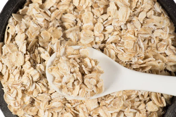 Oat flakes in clay bowl and wooden scoop isolated — Stock Photo, Image