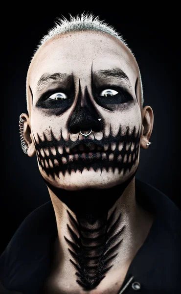 Portrait d'un homme féroce et effrayant avec maquillage du crâne et piercings sur un fond noir . — Photo