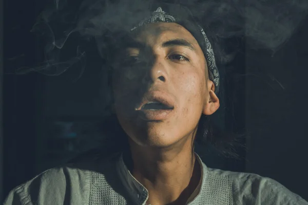 Latino uomo fumare cannabis con un sacco di fumo primo piano, colpo frontale, fumo che esce dalla sua bocca — Foto Stock