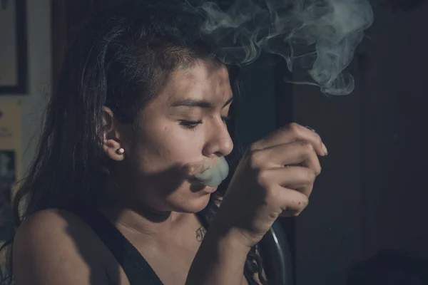 Женщина курит, закрывается дымом и ртом — стоковое фото