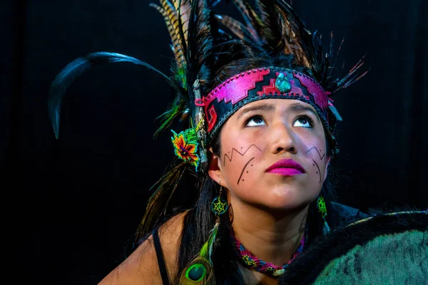 Close up of young woman Teotihuacana, Xicalanca - Toltec in black background, with traditional dress dance with a trappings with feathers and drum — Stockfoto