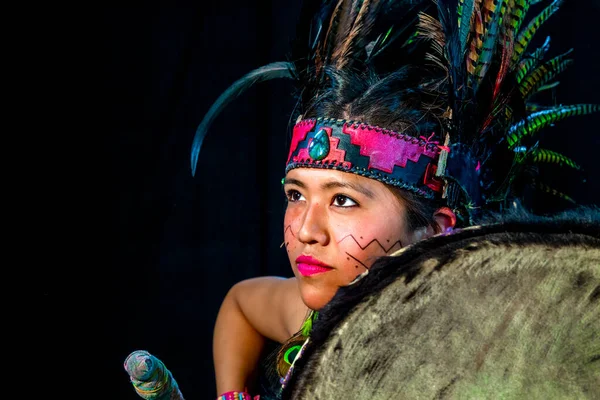 Close up of young woman Teotihuacana, Xicalanca - Toltec in black background, with traditional dress dance with a trappings with feathers and drum — ストック写真