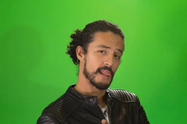 Porträt eines attraktiven Lateinamerikaners in Rockerjacke, Profilbild, junger Mann singt auf grünem Hintergrund Rockstar — Stockfoto