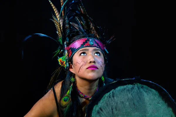 Close up of young woman Teotihuacana, Xicalanca - Toltec in black background, with traditional dress dance with a trappings with feathers and drum — ストック写真