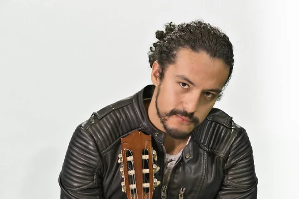 Ritratto di attraente giovane latino in giacca a dondolo, su sfondo bianco, con chitarra acustica — Foto Stock