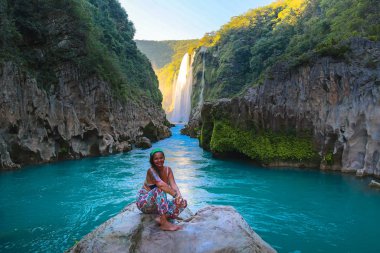 TAMUL, SAN LUIS POTOSI MEXICO - January 6, 2020:young women posing in River amazing crystalline blue water of Tamul waterfall clipart