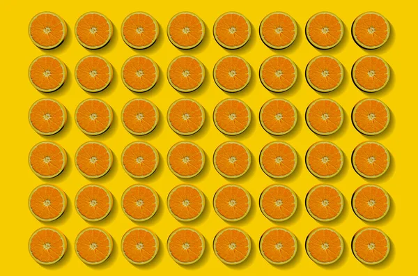 Fruit pattern of fresh orange slices on yellow background. Top view. Copy Space. Pop art