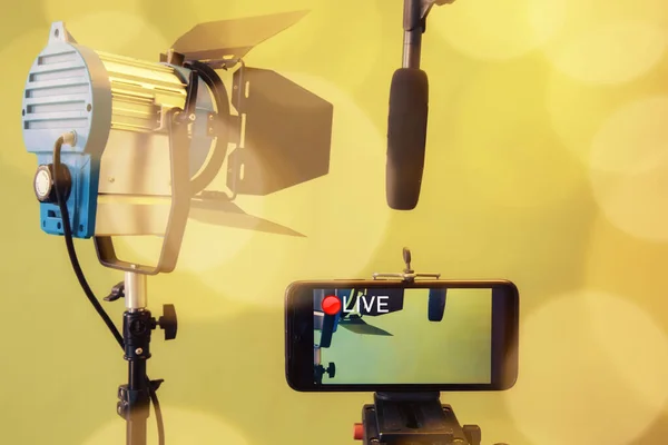 라이브 스트림 비디오 멀티미디어 컨셉트 노란색 배경에 스마트폰 마이크 반사경 — 스톡 사진