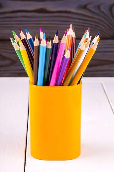 Набір кольорових дерев'яних олівців у жовтому пластиковому склі — стокове фото