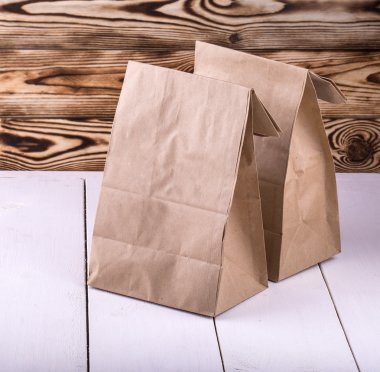 Beyaz ahşap masa üstünde Brown yemek çanta 