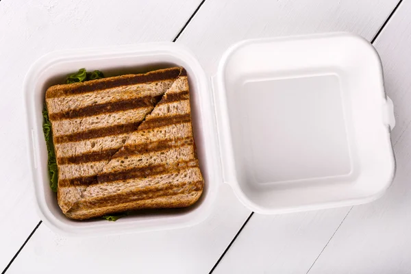 Sandwich caliente en un tazón de plástico sobre fondo de madera blanca —  Fotos de Stock