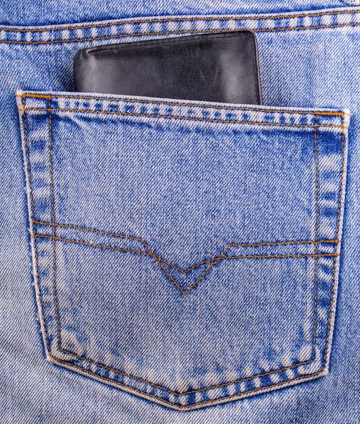 Старий чорний гаманець, що показується в задній кишені — стокове фото