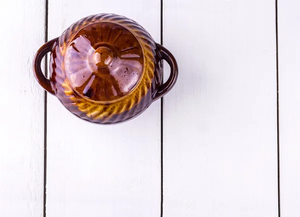 Old crock pot cooking on white wooden  background — Stockfoto