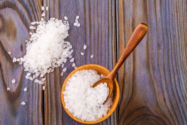 Bir tahta kaşıkla ahşap bir kasede beyaz banyo tuzu