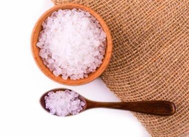 Bir tahta kaşıkla ahşap bir kasede beyaz banyo tuzu