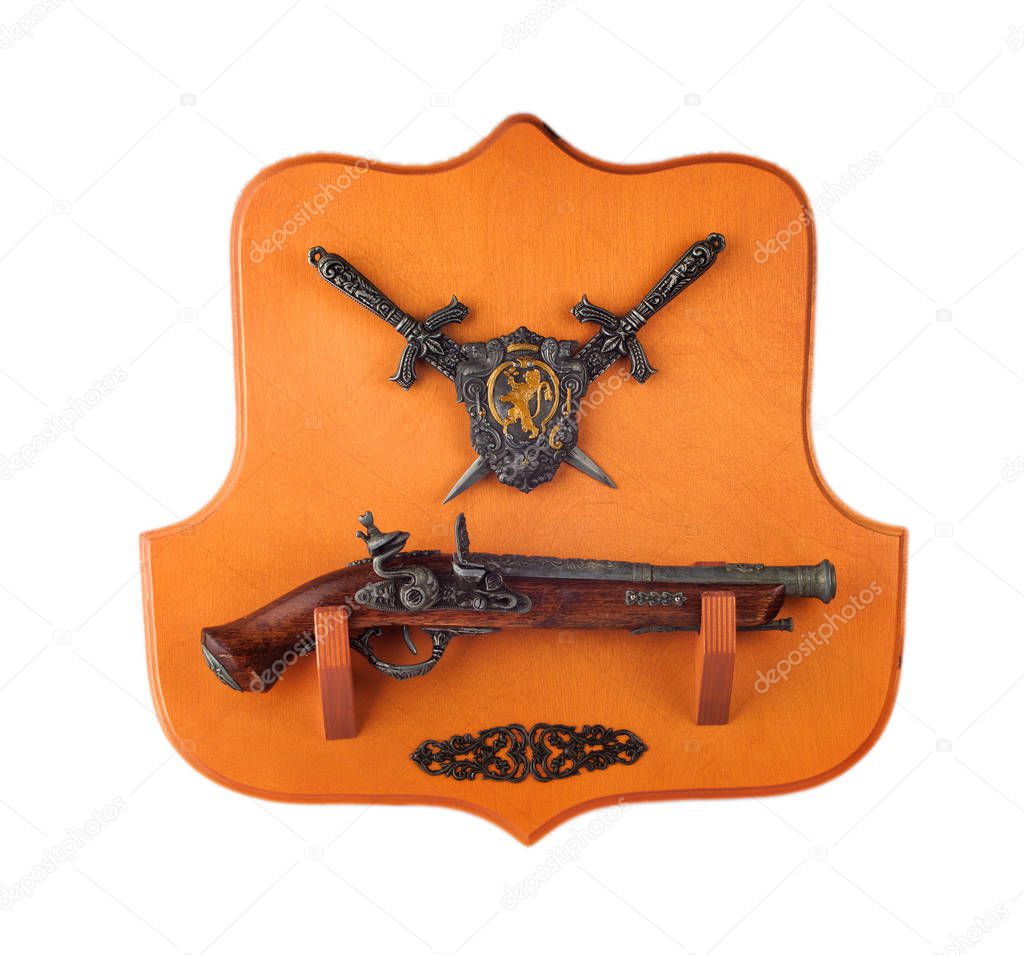 miniature pistol, daggers and coat of arms on the wooden  backgr