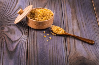 Tahta kaşık kaşık ve kahverengi baston şeker dolu kase