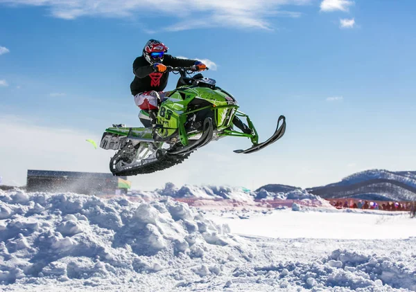 Snowmobile rider jumping through snow. — Stock Photo, Image