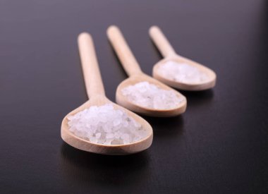 karanlık bir cilalı masa üzerine üç tahta kaşıklar ATH tuz