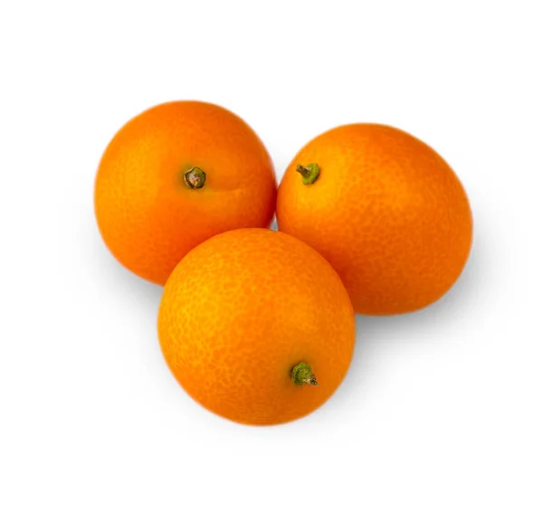 Drei köstliche Kumquats, geschnitzt auf weißem Hintergrund. — Stockfoto