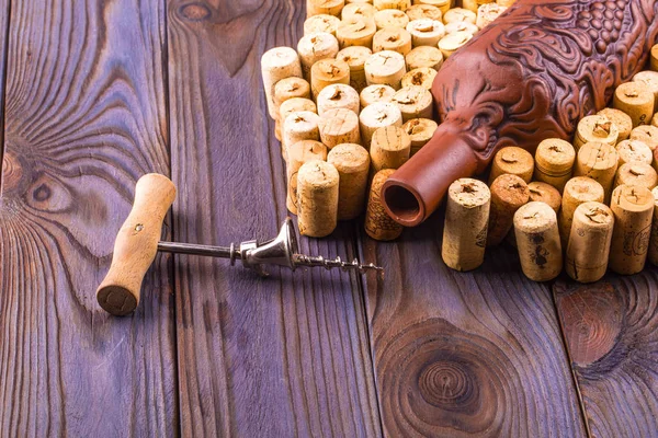 Lera flaska, metall korkskruv och korken på ett träbord. — Stockfoto