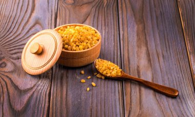 Ahşap bir masa kaşık ile ahşap bir fincan şeker kamışı.