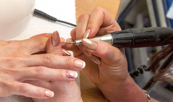 Nail master in rubber gloves make manicure