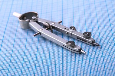 Pergel mavi grafik kağıt üzerinde.