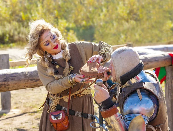 Woman in medieval clothes give to drink the  knight — Stock Photo, Image