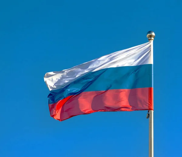 Прапор Росії на тлі синього неба. — стокове фото