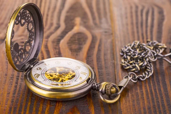 Relógio de bolso antigo deitado sobre um velho fundo de madeira rústica . — Fotografia de Stock
