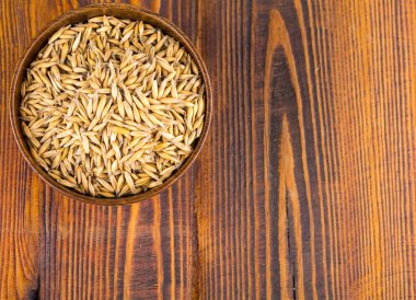 Yulaf kulakları kaynaklanıyor Kupası koyu kahverengi ahşap arka plan üzerinde