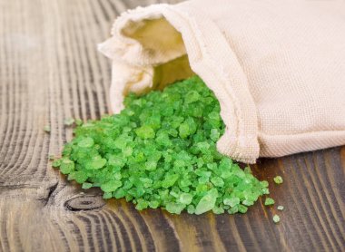 çanta ahşap yüzey üzerinde yeşil banyo tuzu 