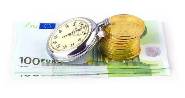 Bitcoins en una pila de cien euros y un reloj de bombilla en whi — Foto de Stock