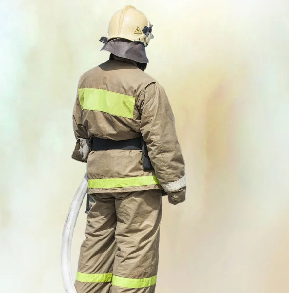 Fireman overalls standing in the smoke. — Stock Photo, Image
