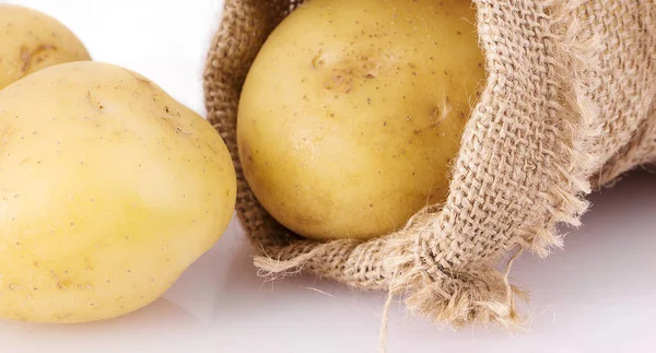 Zak met aardappelen op witte achtergrond. — Stockfoto