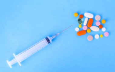 Renkli ilaçlar, tablet, hap ve kapsül ve bir şırınga o