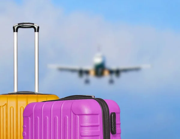 Suitcases and the blure boarding plane in the blue sky. — Stock Photo, Image