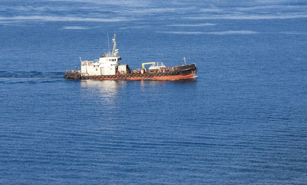 Буксировка судна в солнечный осенний день на синем море — стоковое фото