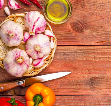 Mutfak arka planında sarımsak, ahşap masada biber.