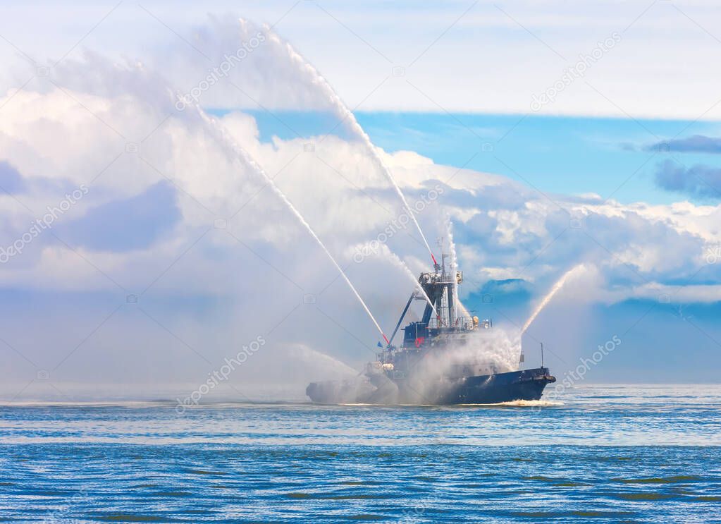 the Floating tug boat is spraying jets of water