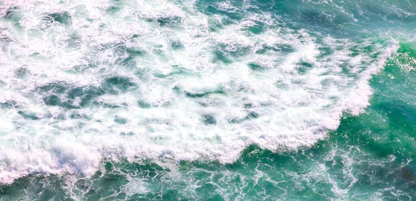 青い海の風光明媚な空中ショットを背景に泡立つ波 — ストック写真