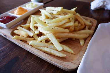 Tahtada patates kızartması, ahşap masa arkasında..