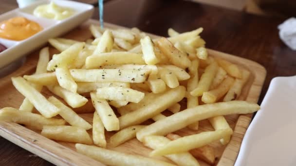 从餐桌上的盘子里取出薯条的特写镜头 不健康饮食 人与垃圾食品概念 — 图库视频影像