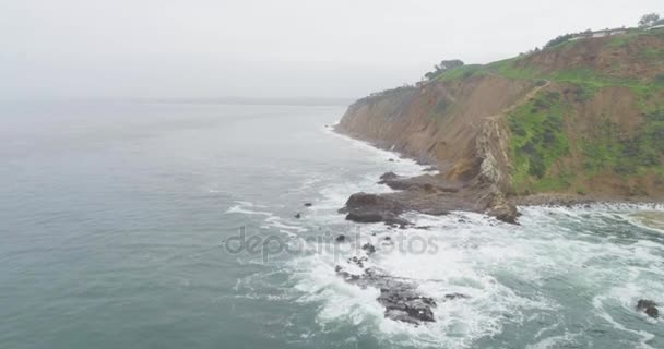 Lotniczych fly obok urwiska: Wybrzeże skaliste plaży w Palos Verdes, California, ptaszki fale uderzając w skałach mglisty dzień — Wideo stockowe