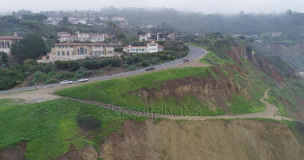 Luchtfoto vliegen uit de buurt van herenhuis naast Cliff: kust rotsachtige strand in Palos Verdes, Californië, mistige dag — Stockvideo